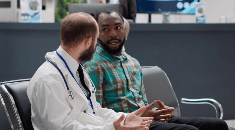 Negli ospedali mancano gli interpreti: un medico parla con un paziente straniero