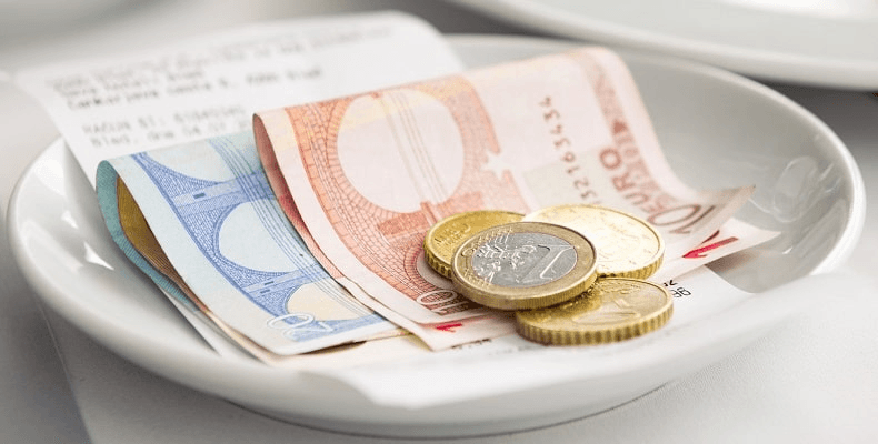 Conto e mancia sul piattino di un bar