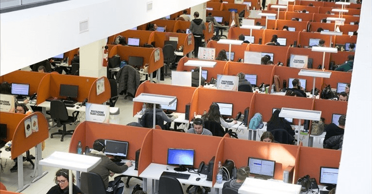 Crisi dei call center, un ufficio con diverse postazioni telefoniche vuote