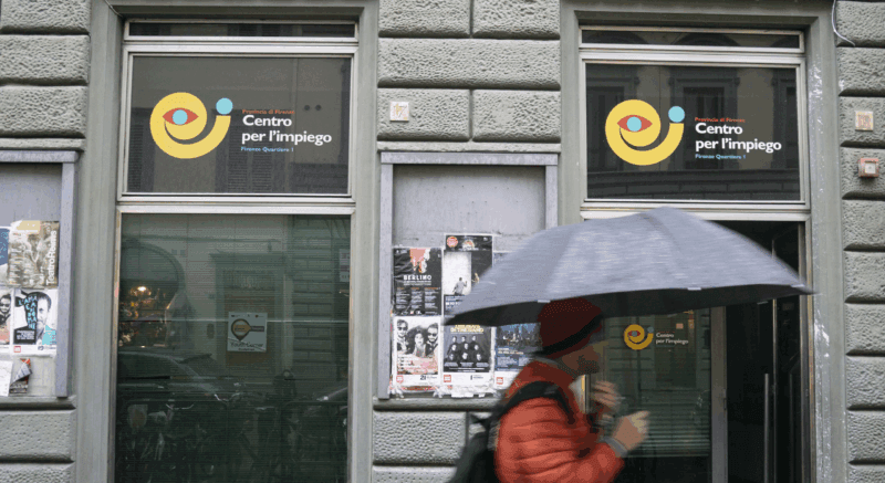Uno dei Centri per l'Impiego di Firenze ignorato dai passanti, sotto la pioggia
